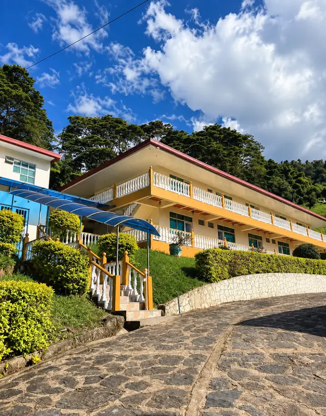 Edificio de habitaciones sobre la ladera, con la entrada empedrada